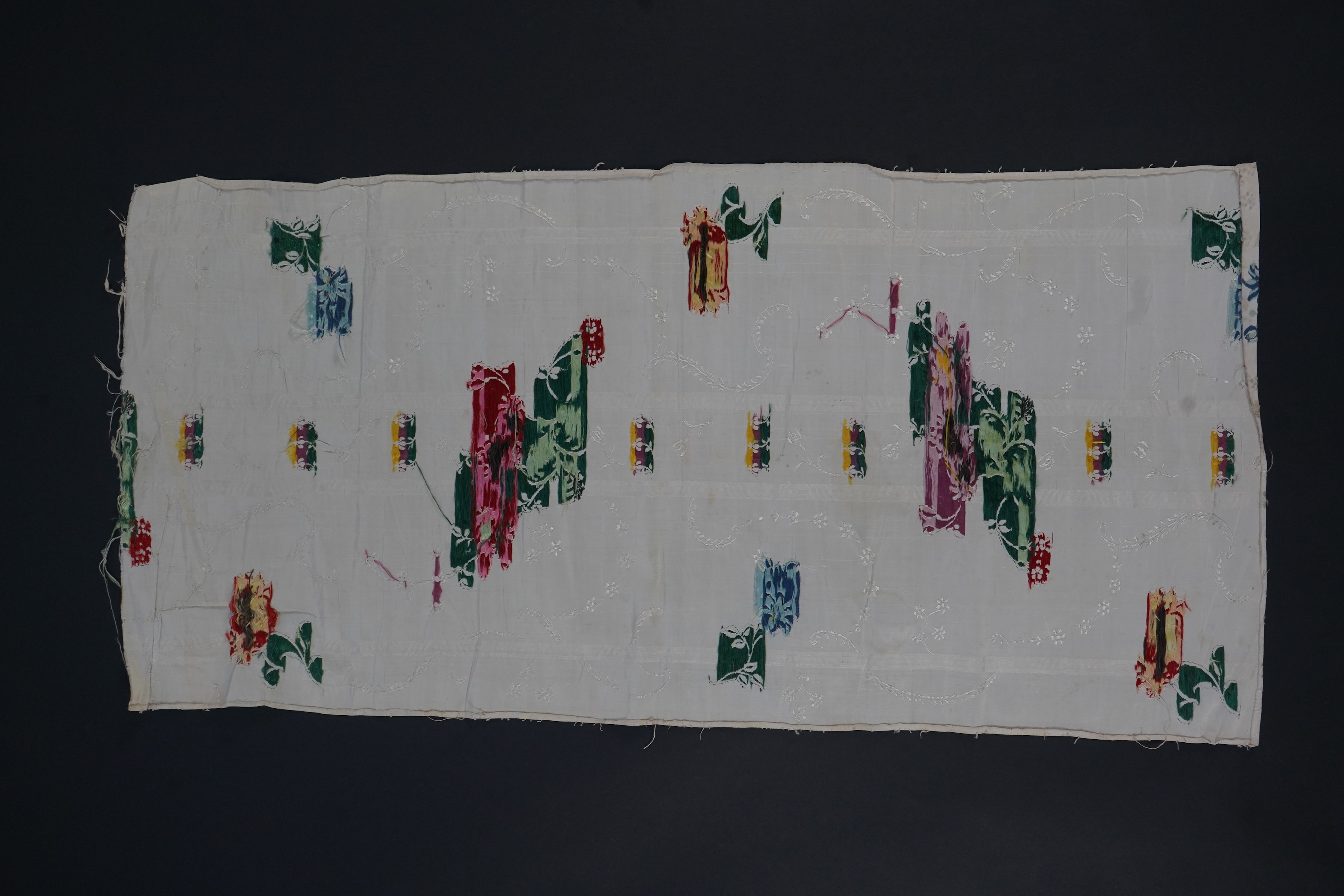 A length of 18th century short loom hand woven Spitalfields silk dress fabric, woven in cream silk with all over multicoloured spot floral motifs in a large repeat. 82cm repeat, total length of fabric 100cm x 48.5cm wide